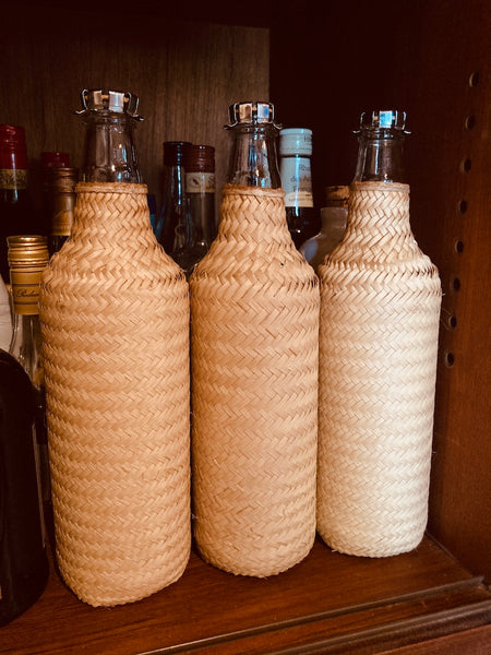 Bouteille recouverte de paille de Carnauba tressée à la main