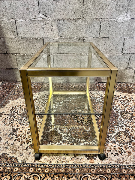 Table basse en métal doré et verre sur roulettes dans le style de Pierre Vandel