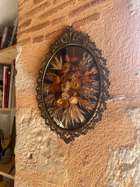 Cadre en métal patiné vintage de fleurs séchées au verre bombé.