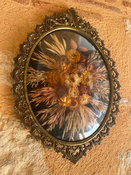 Cadre en métal patiné vintage de fleurs séchées au verre bombé.