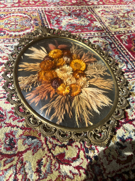 Cadre en métal patiné vintage de fleurs séchées au verre bombé.