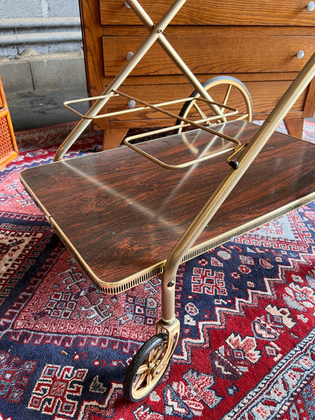 Desserte vintage à roulettes en laiton et formica marron.